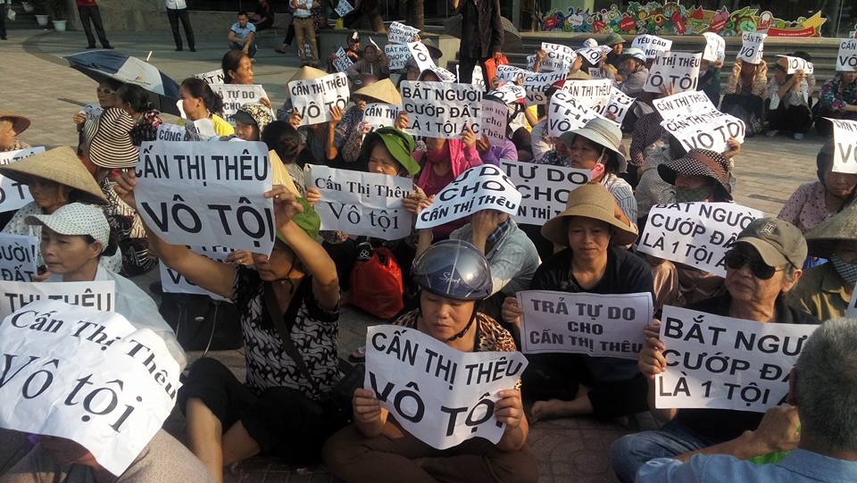 Người dân với những khẩu hiệu trên tay hướng về bà Cấn Thị Thêu (ảnh: Facebook Trịnh Bá Tư)